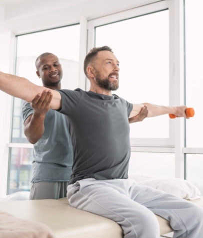 patient lifting dumbbells with therapist