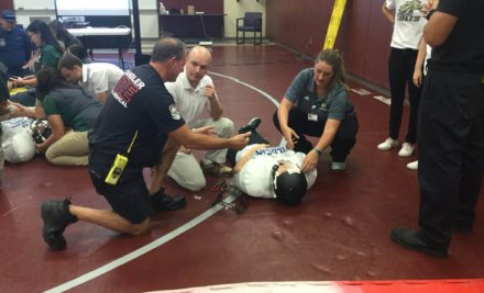 Students learning how to treat injured athletes on the high school sports field